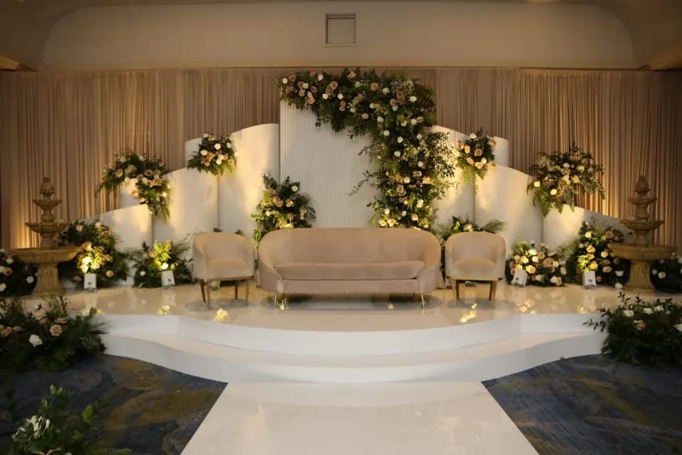 A Luxe stage of tiered white panels and flowers by Diamond Events